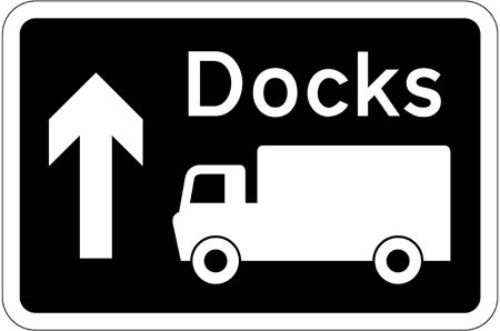Motorway junction ahead leading to a route advised for goods vehicles to the destination shown, which may differ from that for other traffic